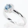 Round Cut Aquamarine Ring with Halo of Diamonds Set in 18ct White Gold