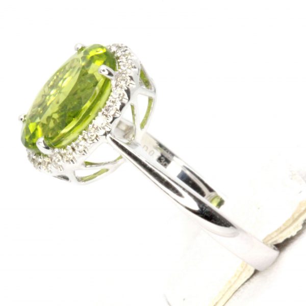 Oval Shape Peridot Ring with Halo of Diamonds Set in 18ct White Gold